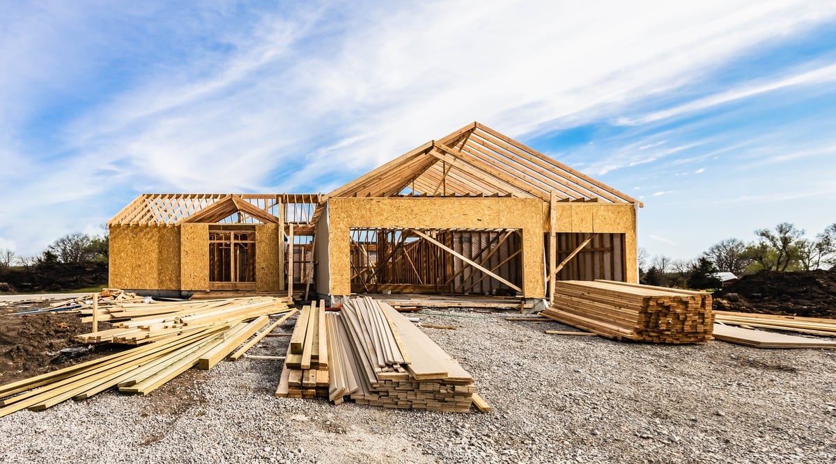 New house under construction, front view from garage door entry with clouds blue sky