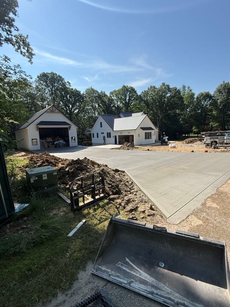 New residential home with concrete driveway and landscaping materials