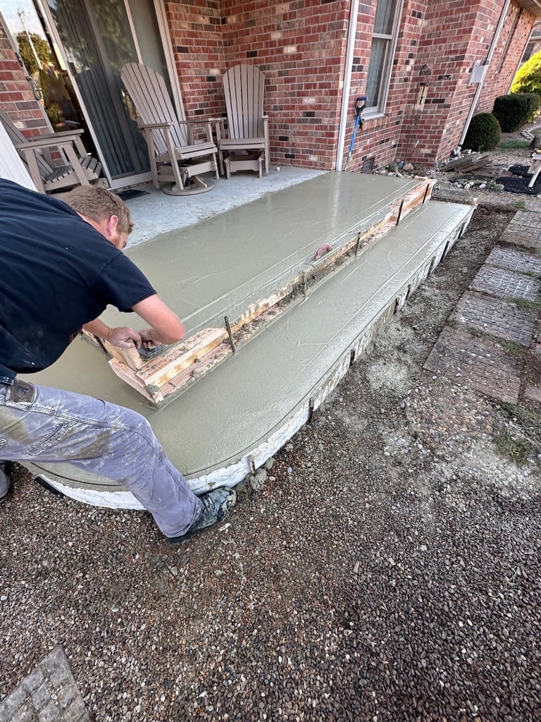 Worker smoothing wet concrete on a residential patio