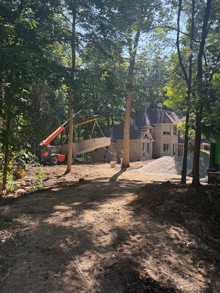 Large-scale commercial construction site with crane near stone house
