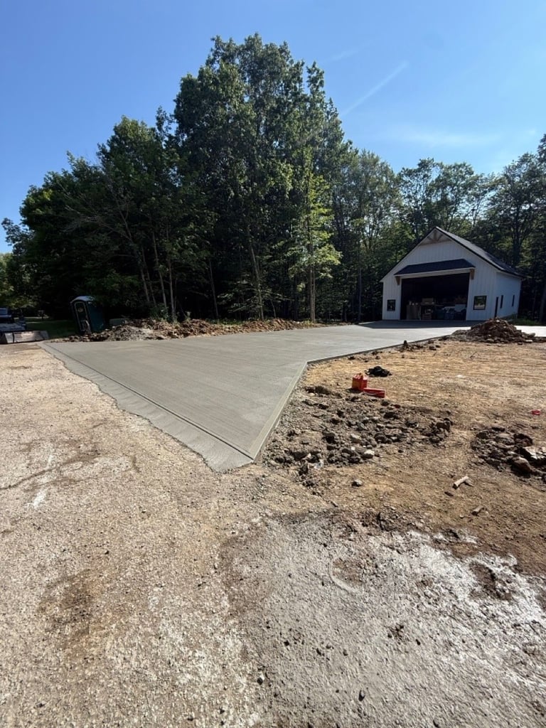 Newly poured concrete driveway next to garage